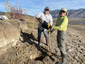 BLM employee and volunteer work together to plant a potted willow at Henrys Lake restoration site
